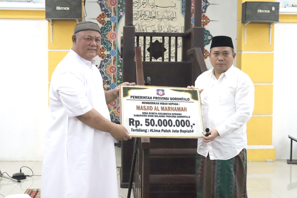 Penjabat Gubernur Gorontalo, Ismail Pakaya menyerahkan bantuan hibah sebesar Rp50 juta untuk perbaikan Masjid Al-Marhamah Kecamatan Suwawa, Bone Bolango kepada Ketua Badan Takmirul Masjid Al-Marhamah Suwawa, Moh. Kris Wartabone, saat melakukan safari Ramadan 1445 H, di masjid tersebut, Selasa (12/3/2024) malam. (F.Kominfo/Hibata.id)