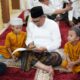 Wali Kota Gorontalo, Marten Taha saat menandatangani buku ramadhan anak-anak. (Foto: Humas Pemkot Gorontalo)