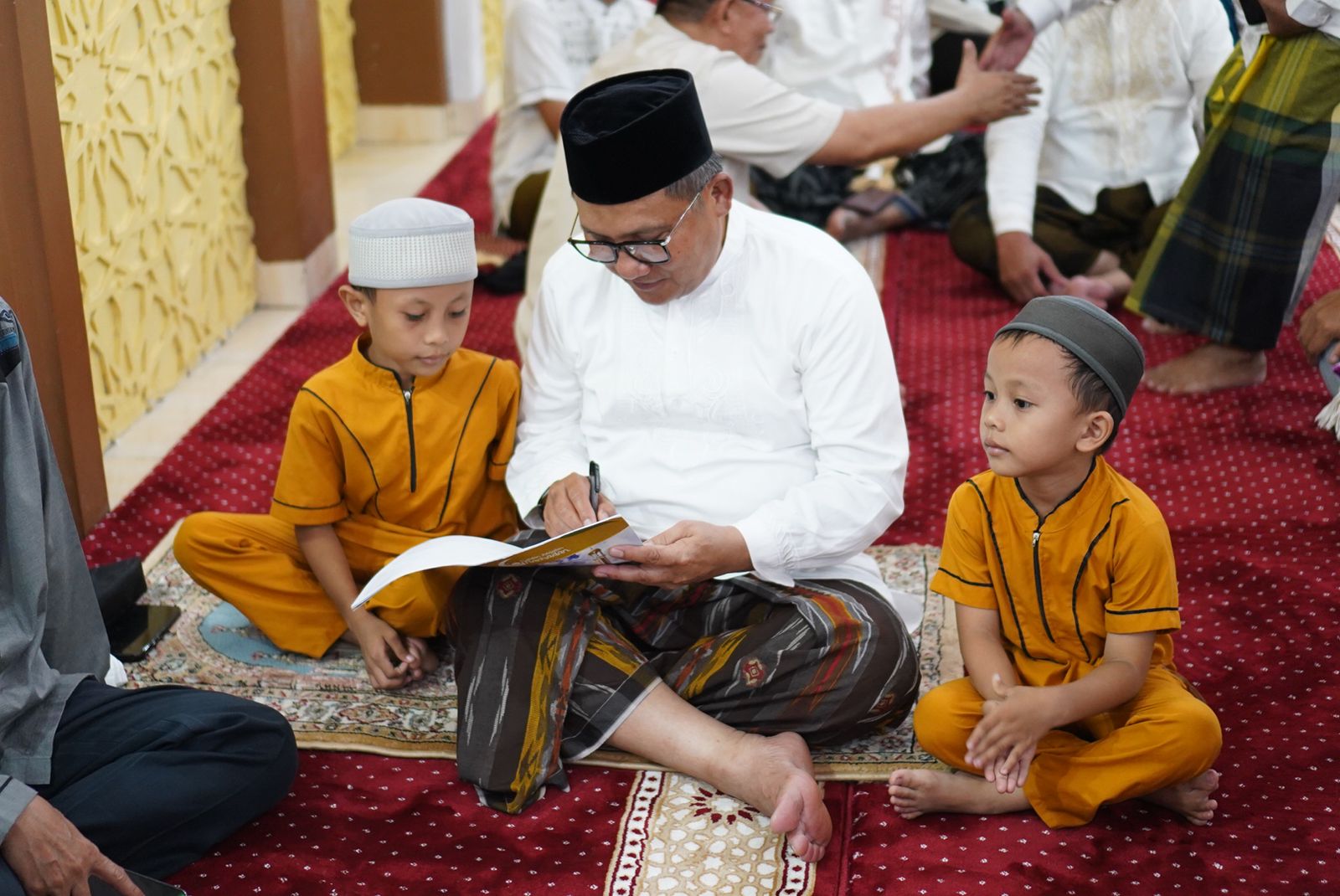 Wali Kota Gorontalo, Marten Taha saat menandatangani buku ramadhan anak-anak. (Foto: Humas Pemkot Gorontalo)