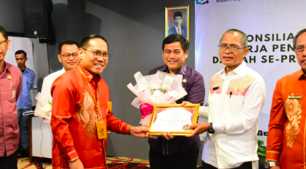 Sekretaris Daerah (Sekda) Ismail Madjid saat menerima penghargaan dari BPJS Kesehatan Cabang Gorontalo. (Foto: Humas Pemkot Gorontalo)