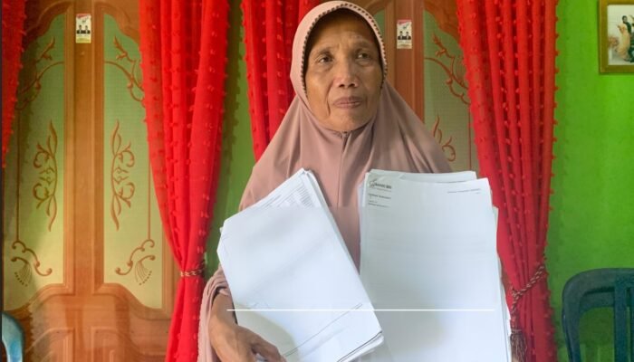 Suarni Pido, salah satu warga Desa Moutong saat menunjukan dokumen terkait penggunaan anggarran dana desa/Hibata.id
