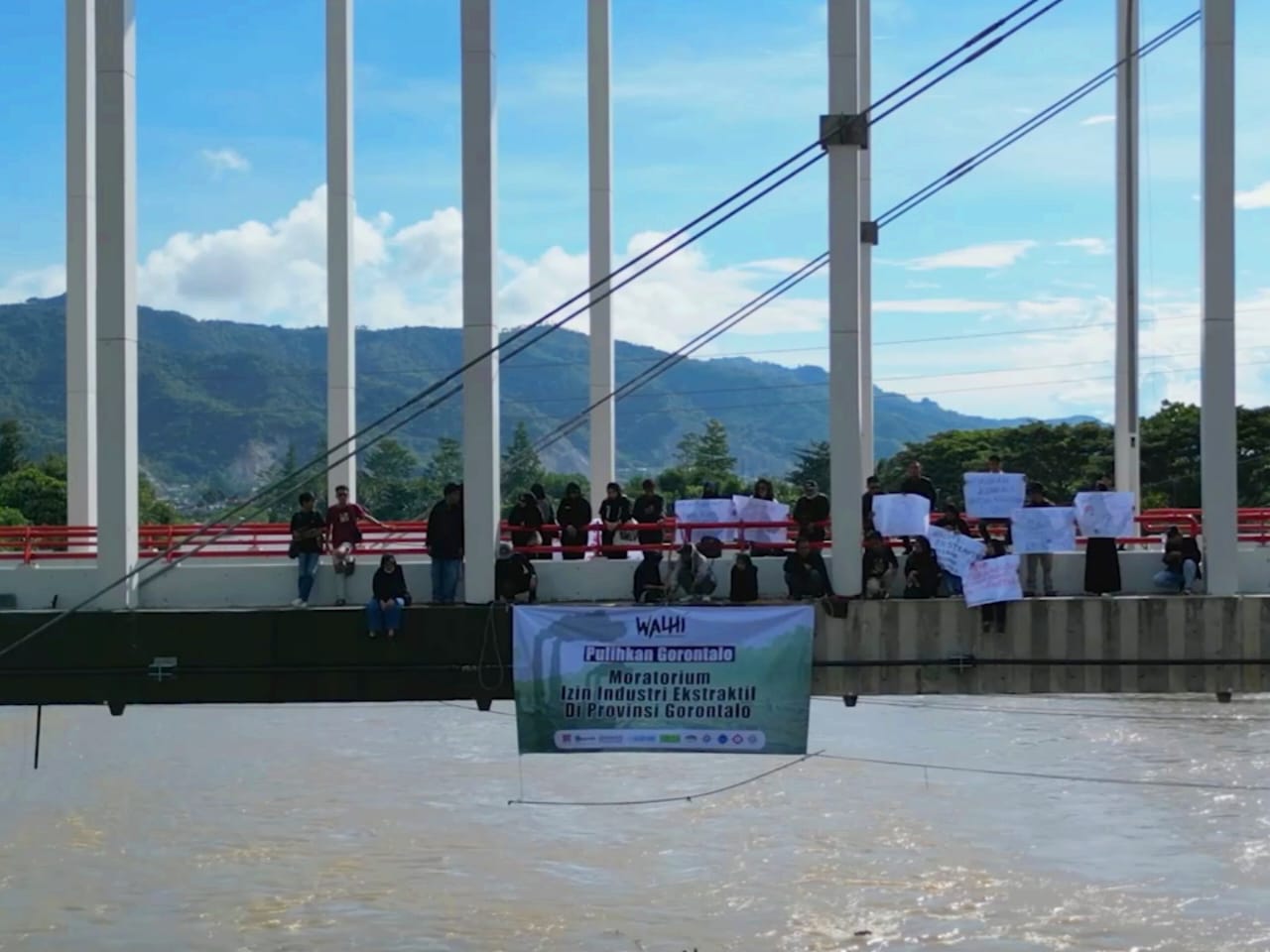 Pembentangan spanduk di jembatan talumolo 2. (Foto: Simpul Walhi Gorontalo)