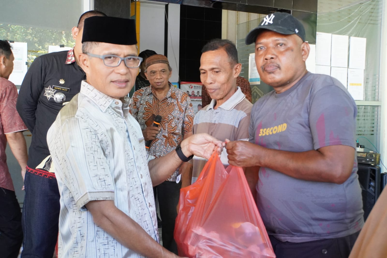 Pejabat (Pj) Wali Kota Gorontalo, Ismail Madjid saat membagikan bantuan bahan pangan kepada P3KE. (Foto: Humas Pemkot Gorontalo)