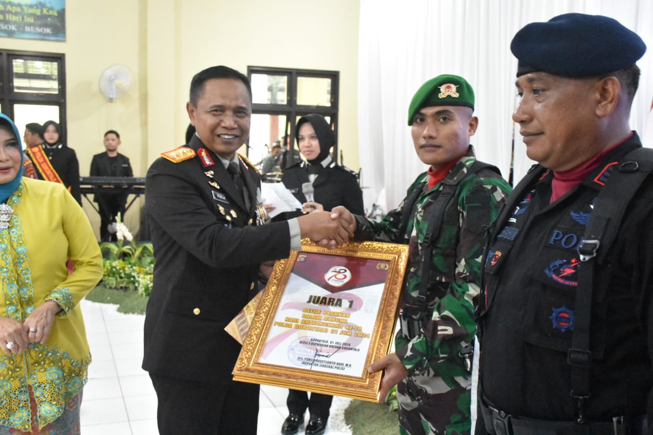 Kapolda Gorontalo Irjen Pol. Drs. Pudji Prasetijanto Hadi saat menyerahkan penghargaan kepada onif 713 Satya Tama Juara 1 Defille HUT Bhayangkara Ke - 78/Hibata.id