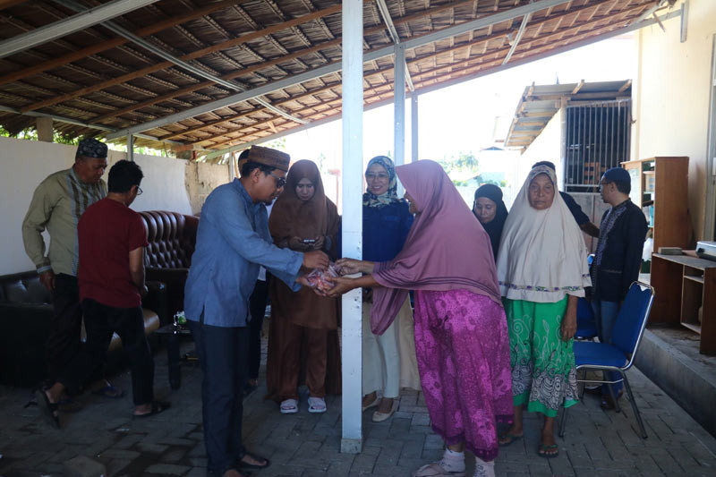 Ketua KPU Gorontalo Utara, Sofyan Jakfar, menyerahkan daging kurban kepada warga sekitar, di hari kedua lebaran Idul Adha, pada Selasa (18/6). FOTO: HUMAS KPU GORONTALO UTARA/Hibata.id