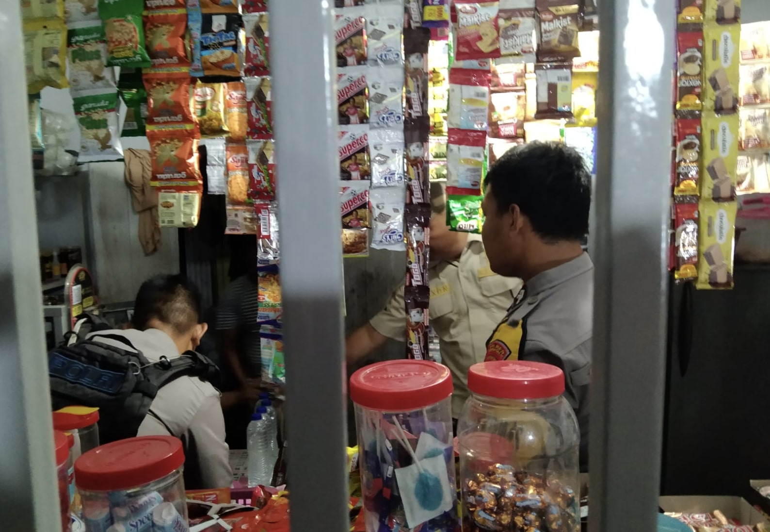 Saat polisi mengamankan sejumlah miras di Salah satu warung di Desa Dumati. (Foto: Humas Polres Gorontalo)