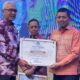 Penjabat Gubernur Gorontalo, Rudy Salahuddin saat menyerahkan Piagam Penghargaan kebijakan Merdeka Belajar kepada Kepala Dinas Pendidikan dan Kebudayaan Kabupaten Bone Bolango, Adrien Andjar di Hotel Aston Kota Gorontalo, Minggu (20/10/2024). (Foto Dok Dinas Pendidikan dan Kebudayaan)/Hibata.id