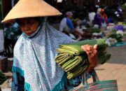 Seorang warga membawa daun pisang dijual keliling di pasar tradisional Blora/infopublik.id/Hibata.id
