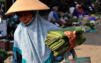 Seorang warga membawa daun pisang dijual keliling di pasar tradisional Blora/infopublik.id/Hibata.id