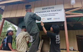 Warga Dusun Bontula saat memasang papan informasi Bantayo Pendidikan Rakyat pada Pada Jumat (25/04) lalu. (Kredit foto: Inhides)