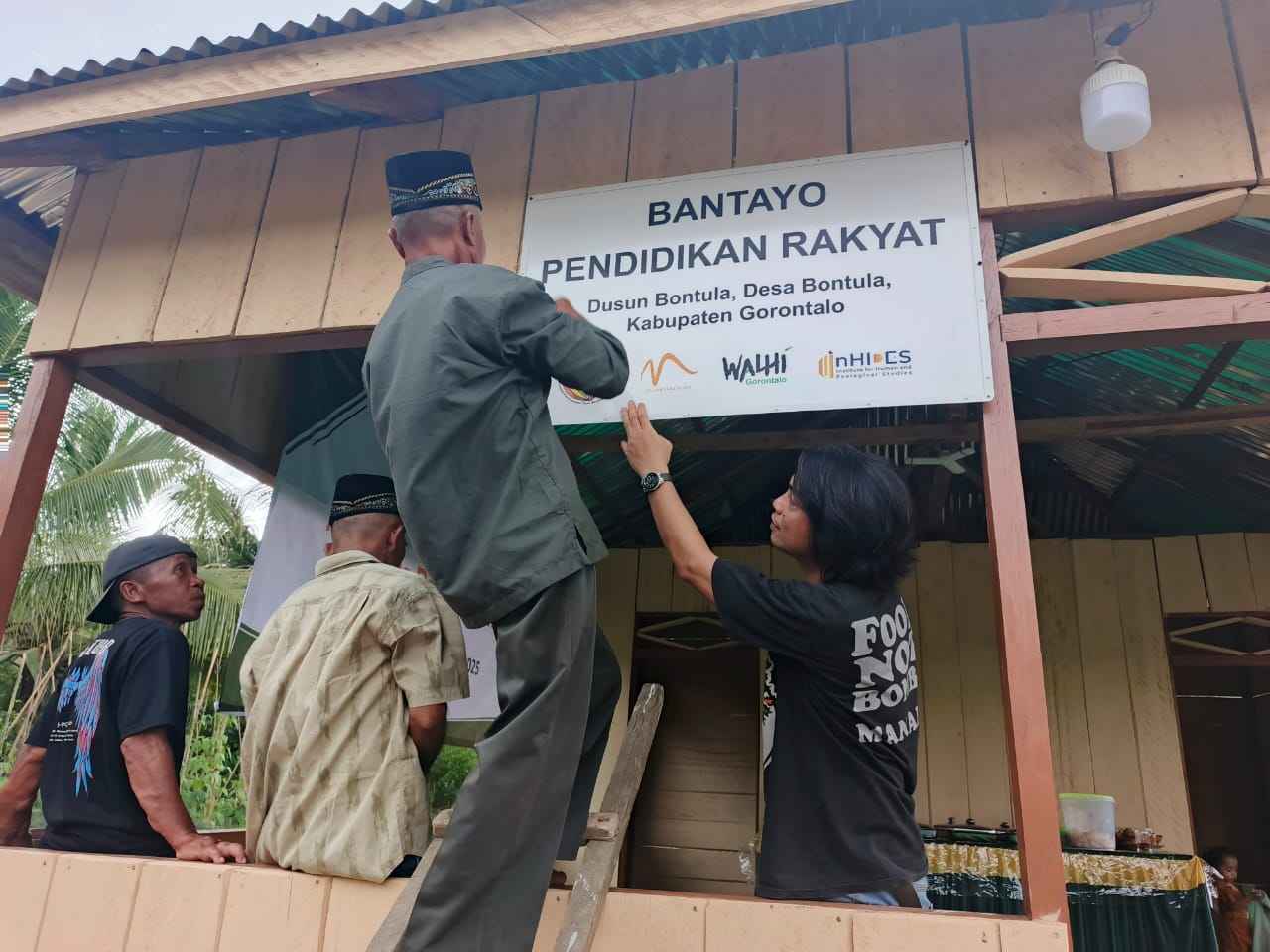 Warga Dusun Bontula saat memasang papan informasi Bantayo Pendidikan Rakyat pada Pada Jumat (25/04) lalu. (Kredit foto: Inhides)
