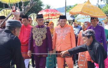 Bupati Bone Bolango, Ismet Mile, bersama Wakil Bupati Risman Tolingguhu, saat menjalani prosesi adat Mopotilolo perdana di dua kecamatan, yakni Kecamatan Kabila Bone dan Kecamatan Bonepantai, Jumat (2/5/2025). (Foto : AKP)/Hibata.id