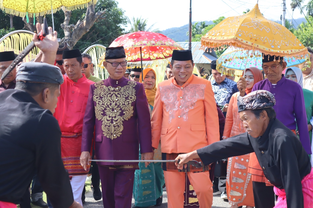 Bupati Bone Bolango, Ismet Mile, bersama Wakil Bupati Risman Tolingguhu, saat menjalani prosesi adat Mopotilolo perdana di dua kecamatan, yakni Kecamatan Kabila Bone dan Kecamatan Bonepantai, Jumat (2/5/2025). (Foto : AKP)/Hibata.id