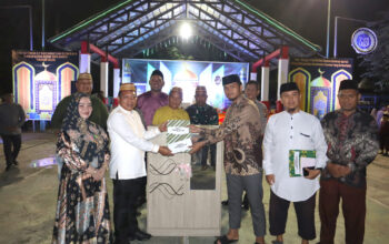 Wakil Bupati Risman Tolingguhu didampingi istri tercinta Gamaria Djura resmi menutup pelaksanaan STQH ke-XI tingkat Kecamatan Suwawa tahun 2025 sekaligus menyerahkan piagam penghargaan dan bonus kepada para pemenang, di Lapangan Volly Kecamatan Suwawa, Selasa (13/5/2025) malam. (F.AKP)/Hibata.id