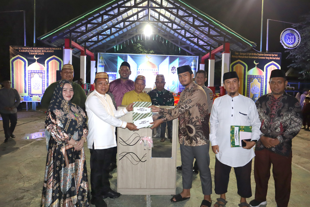 Wakil Bupati Risman Tolingguhu didampingi istri tercinta Gamaria Djura resmi menutup pelaksanaan STQH ke-XI tingkat Kecamatan Suwawa tahun 2025 sekaligus menyerahkan piagam penghargaan dan bonus kepada para pemenang, di Lapangan Volly Kecamatan Suwawa, Selasa (13/5/2025) malam. (F.AKP)/Hibata.id