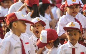 Seorang siswa menguap menahan kantuk sebelum upacara di SD. Foto: Faizal Fanani/Hibata.id