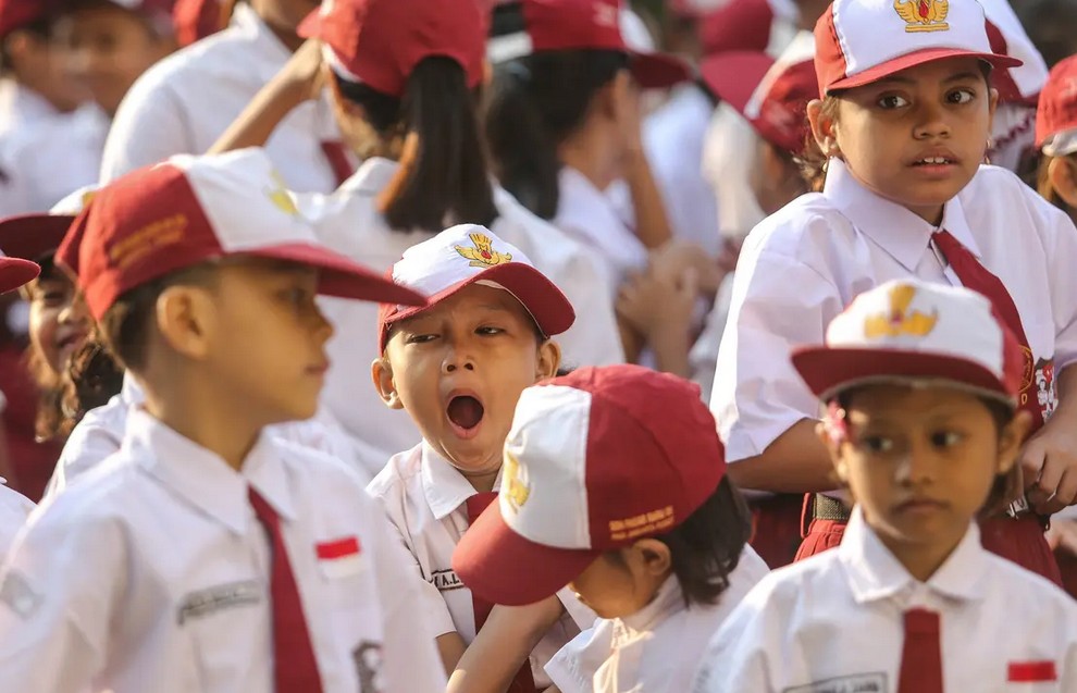 Seorang siswa menguap menahan kantuk sebelum upacara di SD. Foto: Faizal Fanani/Hibata.id