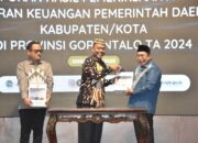 Wali Kota Gorontalo Adhan Dambea saat menerima opini Wajar Tanpa Pengecualian (WTP) dari Badan Pemeriksa Keuangan (BPK) Perwakilan Provinsi Gorontalo, Senin (19/5/2025). (Foto: Humas Pemkot Gorontalo)