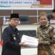 Bupati Ismet Mile saat menyerahkan dokumen Ranperda Pertanggungjawaban pelaksanaan anggaran pendapatan dan belanja daerah Kabupaten Bone Bolango tahun anggaran 2024 kepada Ketua DPRD Faisal Yunus pada Rapat Paripurna Pembicaraan Tingkat I, di ruang Sidang DPRD Bone Bolango. Dok. Humas/Hibata.id