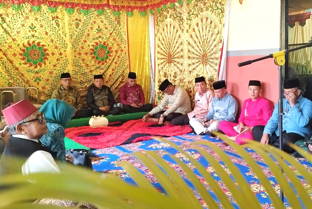 Bupati Bone Bolango, Ismet Mile dan Wakil Bupati, Risman Tolingguhu menjalani prosesi Adat Mopotilolo di Kecamatan Suwawa Tengah, Kamis (12/6/2025). (F.AKP)/Hibata.id
