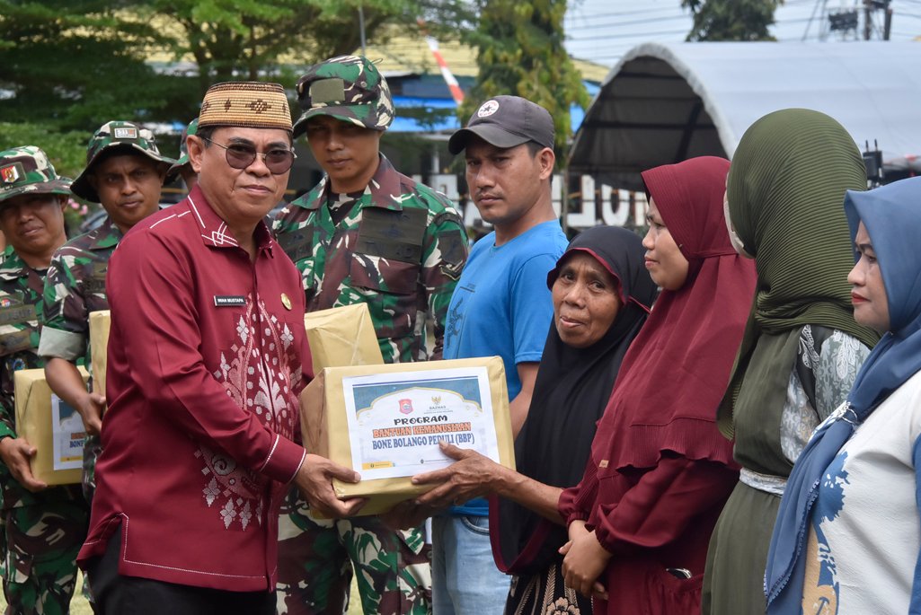 Sekda Iwan Mustapa saat menyerahkan paket bantuan kemanusiaan melalui program Bone Bolango Peduli (BBP) bagi warga yang kurang mampu dan kaum dhuafa atau para mustahik di Desa Molutabu Kecamatan Kabila Bone, di sela-sela upacara penutupan program TMMD ke-125 tahun 2025, di Lapangan RTH Desa Molutabu Kecamatan Kabila Bone, Kamis (21/8/2025). (F.AKP-Tim Redaksi)/Hibata.id
