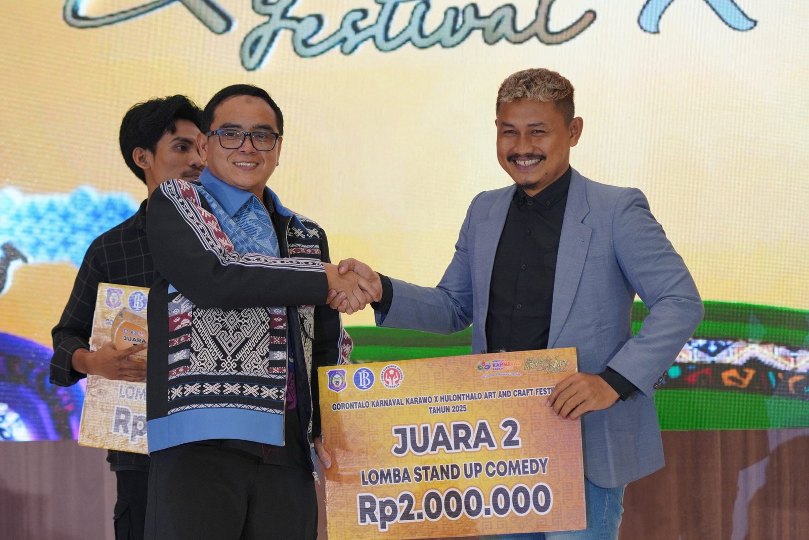 Deputi Direktur KPw Bank Indonesia Gorontalo, Bambang Satya Permana, menyerahkan hadiah kepada salah satu komedian Gorontalo, Bapu Choki/Hibata.id