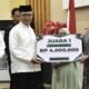Sekretaris Daerah (Sekda) Kota Gorontalo, Ismail Majid saat menyerahkan hadiah kepada pemenang Festival Barzanji Kota Gorontalo 2025. (Foto: Humas Pemkot Gorontalo)
