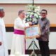 Wakil Wali Kota Indra Gobel saat menerima penghargaan dari Paroki Santo Kristoforus Gorontalo. (Foto: Humas Pemkot Gorontalo)