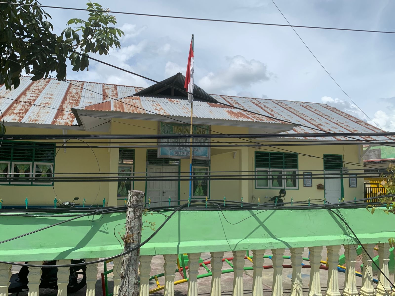 Kabel listrik dan telekomunikasi menjuntai di depan TK Aisyiyah Bustanul Athfal saat proyek pelebaran Jalan Brigjen Piola Isa Gorontalo berlangsung. Wali murid dan LP3G soroti risiko keselamatan siswa/Hibata.id