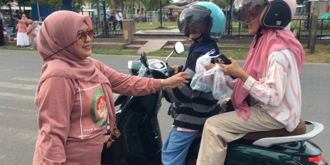 Ketua DWP Bone Bolango, dr.Nurliana Ibrahim saat membagikan takjil kepada masyarakat, Sabtu (!4/3/2026). (F.Indra/Diskominfo/Hibata.id