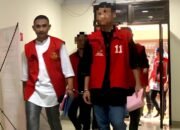 Muhammad Amin Ramadhan, lulusan Institut Pemerintahan Dalam Negeri (IPDN), memasuki ruang sidang utama Pengadilan Negeri Gorontalo dengan mengenakan rompi tahanan dan kedua tangan terborgol saat sidang perdana digelar/Hibata.id