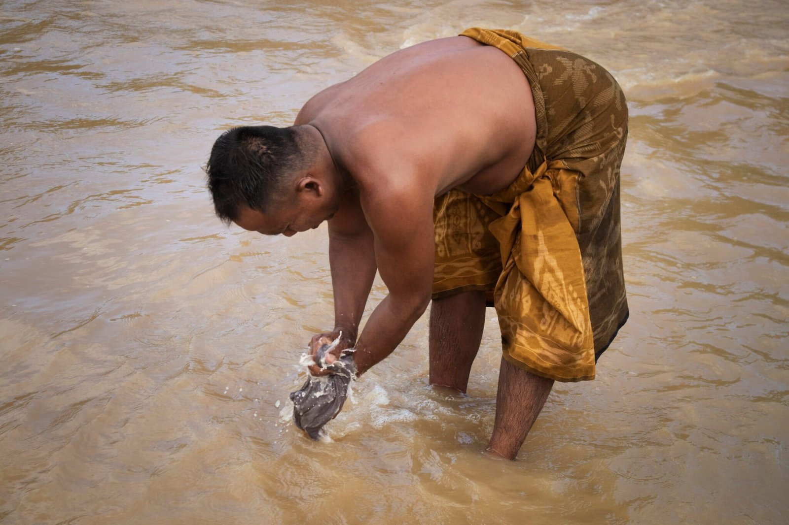 Samin, terpaksa mencuci pakaian di Sungai Popoyato meski kondisinya keruh. Foto: Sarjan Lahay/Mongabay Indonesia/Hibata.id
