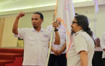 Ketua SMSI Gorontalo, Irwanto Achmad, menyerahkan bendera pataka sebagai simbol amanah dan tanggung jawab kepada pengurus SMSI kabupaten dan kota se-Gorontalo pada Musda II SMSI Gorontalo di Hotel Fox Gorontalo, Sabtu (13/6/2026)/Hibata.id