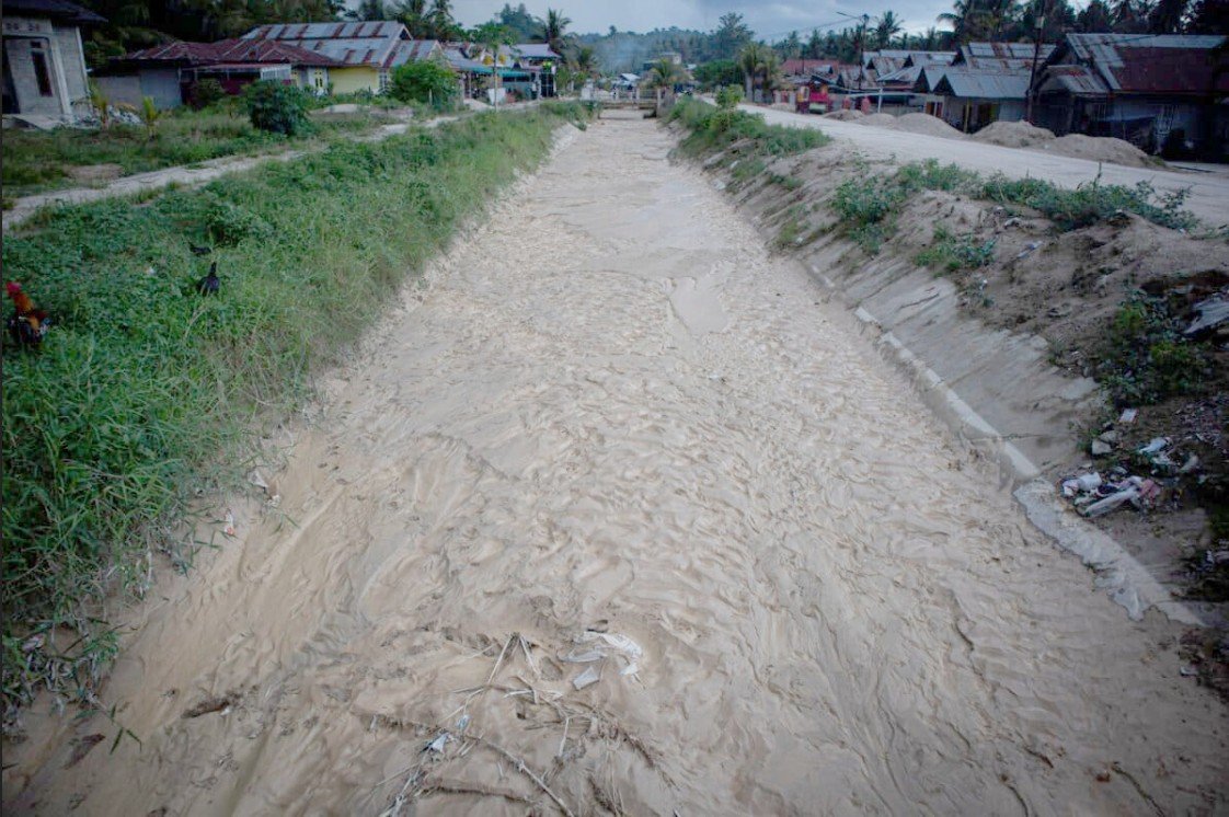 Kondisi saluran irigasi di Kecamatan Duhiadaa, Kabupaten Pohuwato, yang mengalami pendangkalan akibat sedimentasi. Petani mengeluhkan kualitas air yang semakin keruh dan berdampak pada produktivitas sawah. Foto: Sarjan Lahay/Mongabay Indonesia.
