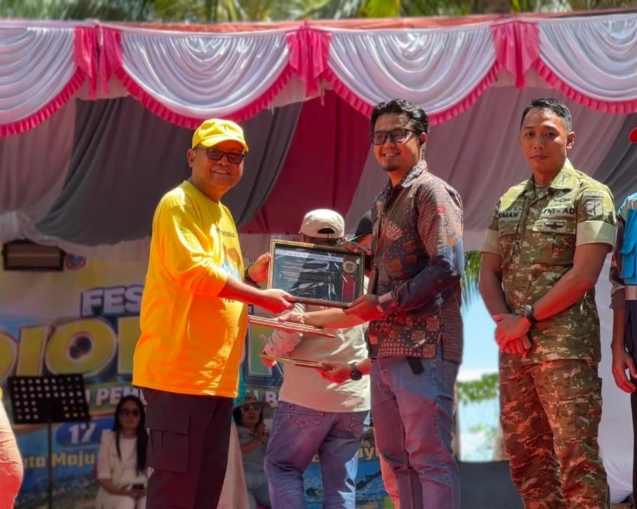 Bupati Gorontalo Utara menyerahkan piagam penghargaan kepada Manager PLN Nusantara Power Unit Pembangkitan (UP) Gorontalo, Hubertus Tri Adi Nugroho, pada pembukaan Festival Dionumo 2026/Hibata.id