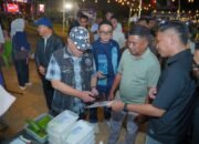 Bupati Kabupaten Gorontalo Sopian Puhi (kiri) didampingi Kepala Kantor Perwakilan Bank Indonesia Provinsi Gorontalo Bambang Satya Permana (kanan) saat menyambangi salah satu stan pelaku usaha kuliner pada peluncuran QRIS Tap di Gorontalo/Hibata.id