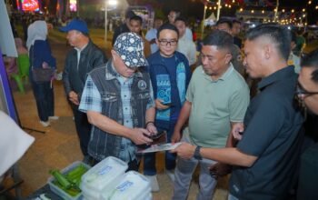 Bupati Kabupaten Gorontalo Sopian Puhi (kiri) didampingi Kepala Kantor Perwakilan Bank Indonesia Provinsi Gorontalo Bambang Satya Permana (kanan) saat menyambangi salah satu stan pelaku usaha kuliner pada peluncuran QRIS Tap di Gorontalo/Hibata.id