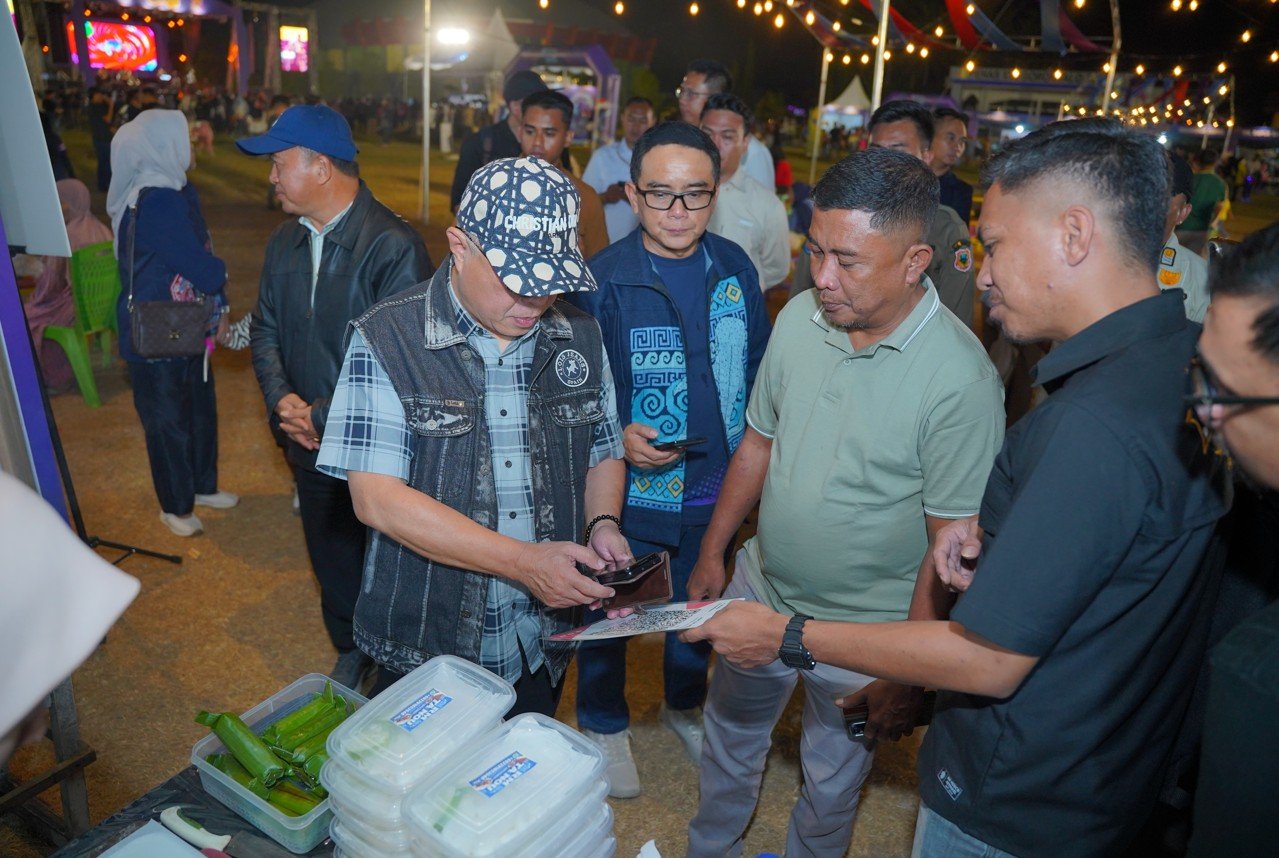 Bupati Kabupaten Gorontalo Sopian Puhi (kiri) didampingi Kepala Kantor Perwakilan Bank Indonesia Provinsi Gorontalo Bambang Satya Permana (kanan) saat menyambangi salah satu stan pelaku usaha kuliner pada peluncuran QRIS Tap di Gorontalo/Hibata.id