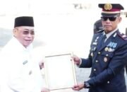 Wali Kota Gorontalo Adhan Dambea menyerahkan piagam penghargaan kepada dua kepolisian sektor, yakni Polsek Kota Utara dan Polsek Kota Selatan. (Foto: Humas)