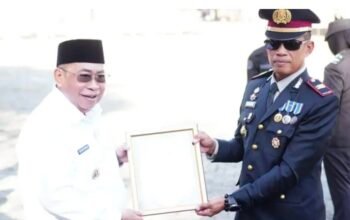 Wali Kota Gorontalo Adhan Dambea menyerahkan piagam penghargaan kepada dua kepolisian sektor, yakni Polsek Kota Utara dan Polsek Kota Selatan. (Foto: Humas)