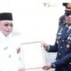 Wali Kota Gorontalo Adhan Dambea menyerahkan piagam penghargaan kepada dua kepolisian sektor, yakni Polsek Kota Utara dan Polsek Kota Selatan. (Foto: Humas)