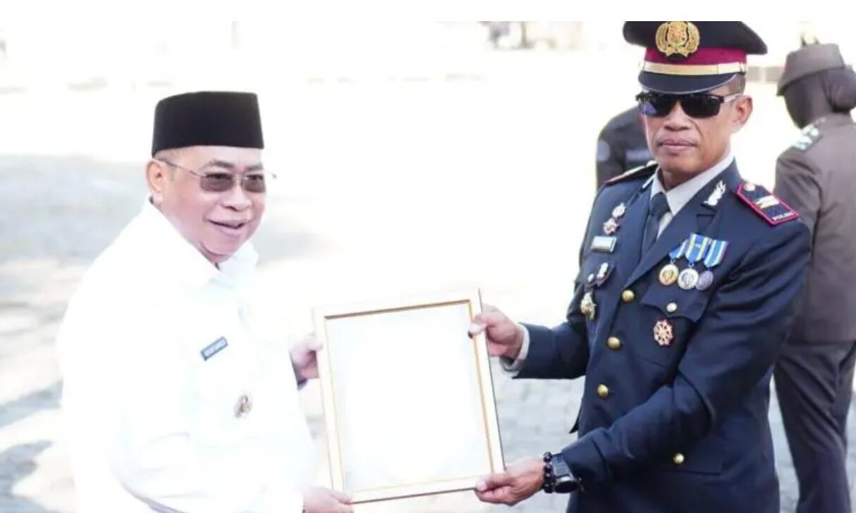 Wali Kota Gorontalo Adhan Dambea menyerahkan piagam penghargaan kepada dua kepolisian sektor, yakni Polsek Kota Utara dan Polsek Kota Selatan. (Foto: Humas)