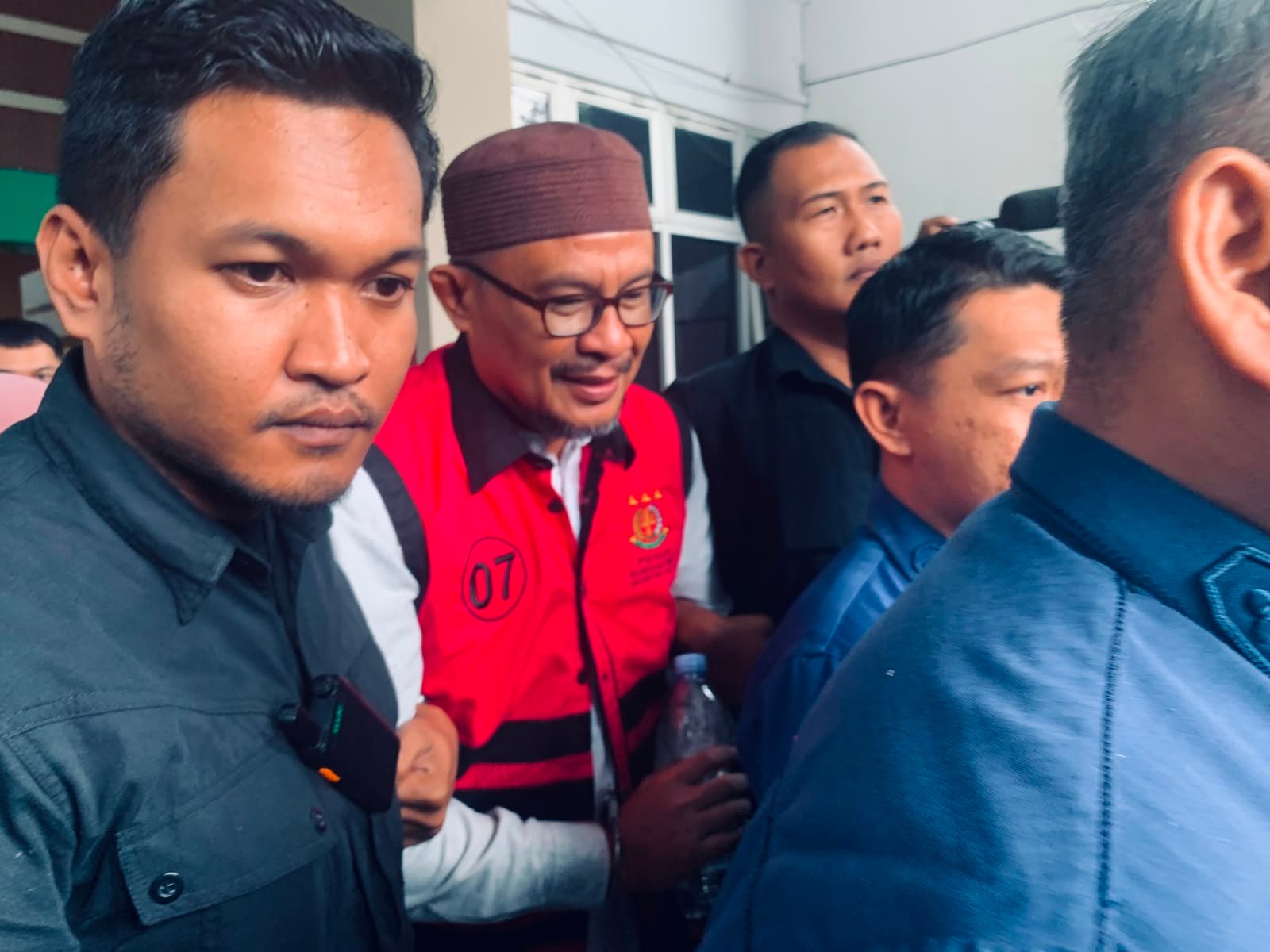 Masran Rauf berjalan menuju mobil tahanan usai menjalani pemeriksaan di Kantor Kejaksaan Tinggi Gorontalo, Kamis (23/7/2026). Kejati Gorontalo menahan Masran setelah menetapkannya sebagai tersangka dalam perkara dugaan korupsi pengadaan Command Center Video Wall Tahun Anggaran 2022/Hibata.id