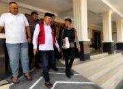 Terdakwa kasus dugaan korupsi Program Hibah Air Minum SR-MBR PUDAM Tirta Gerbang Emas Gorontalo Utara, Muksin Badar, digiring menuju kendaraan usai menjalani sidang pembacaan putusan di Pengadilan Tipikor pada Pengadilan Negeri Gorontalo, Jumat (24/7/2026)/Hibata.id