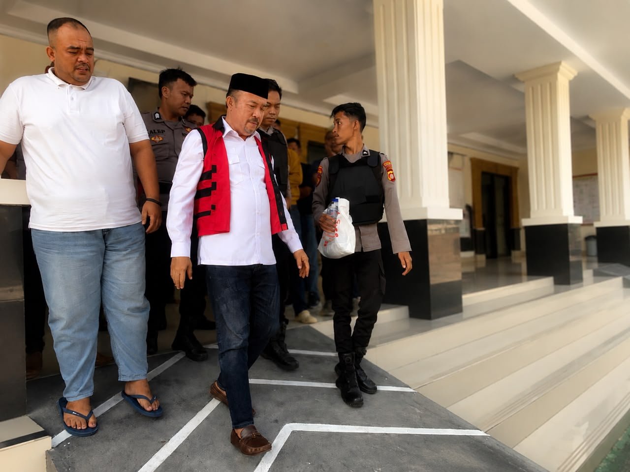 Terdakwa kasus dugaan korupsi Program Hibah Air Minum SR-MBR PUDAM Tirta Gerbang Emas Gorontalo Utara, Muksin Badar, digiring menuju kendaraan usai menjalani sidang pembacaan putusan di Pengadilan Tipikor pada Pengadilan Negeri Gorontalo, Jumat (24/7/2026)/Hibata.id