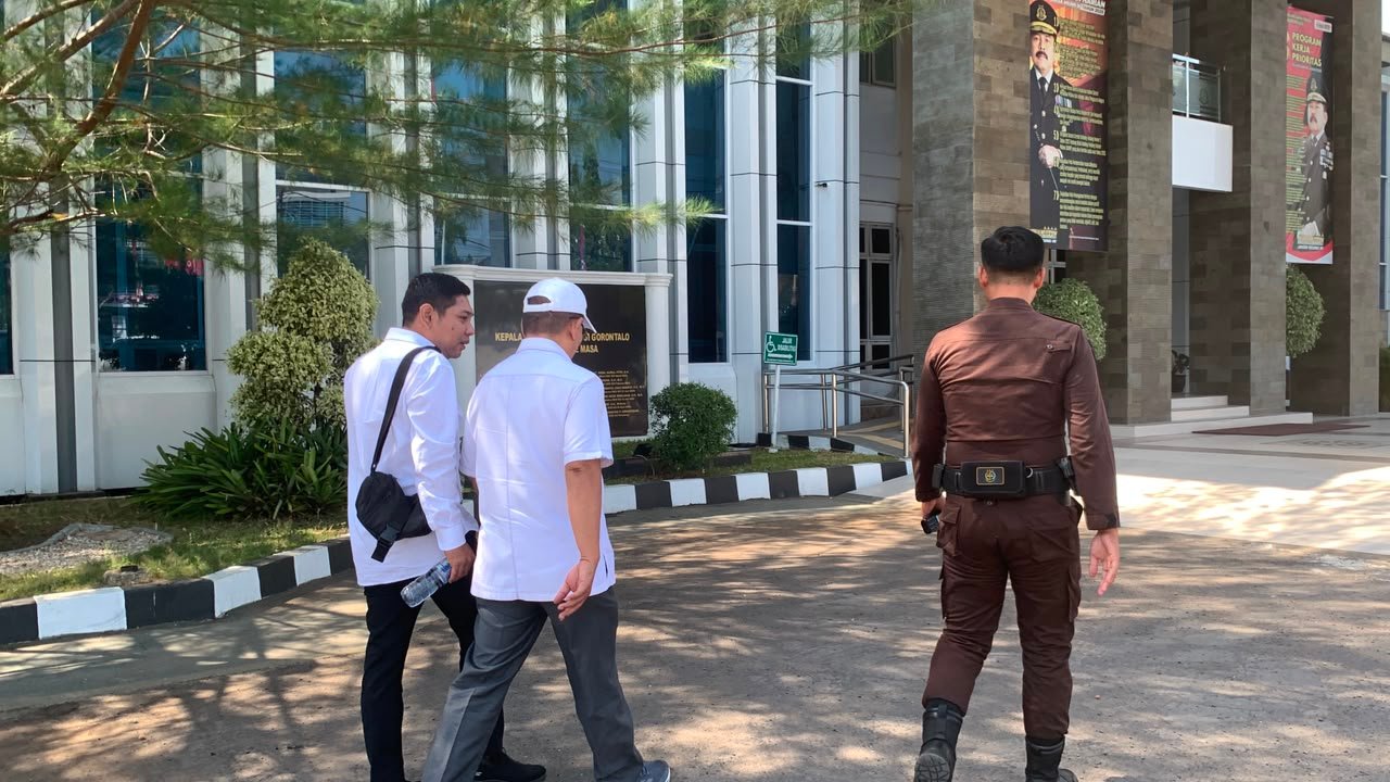 Ketua KONI Provinsi Gorontalo didampingi kuasa hukum saat tiba di Kantor Kejati Gorontalo, Jumat (21/8/2026)/Hibata.id