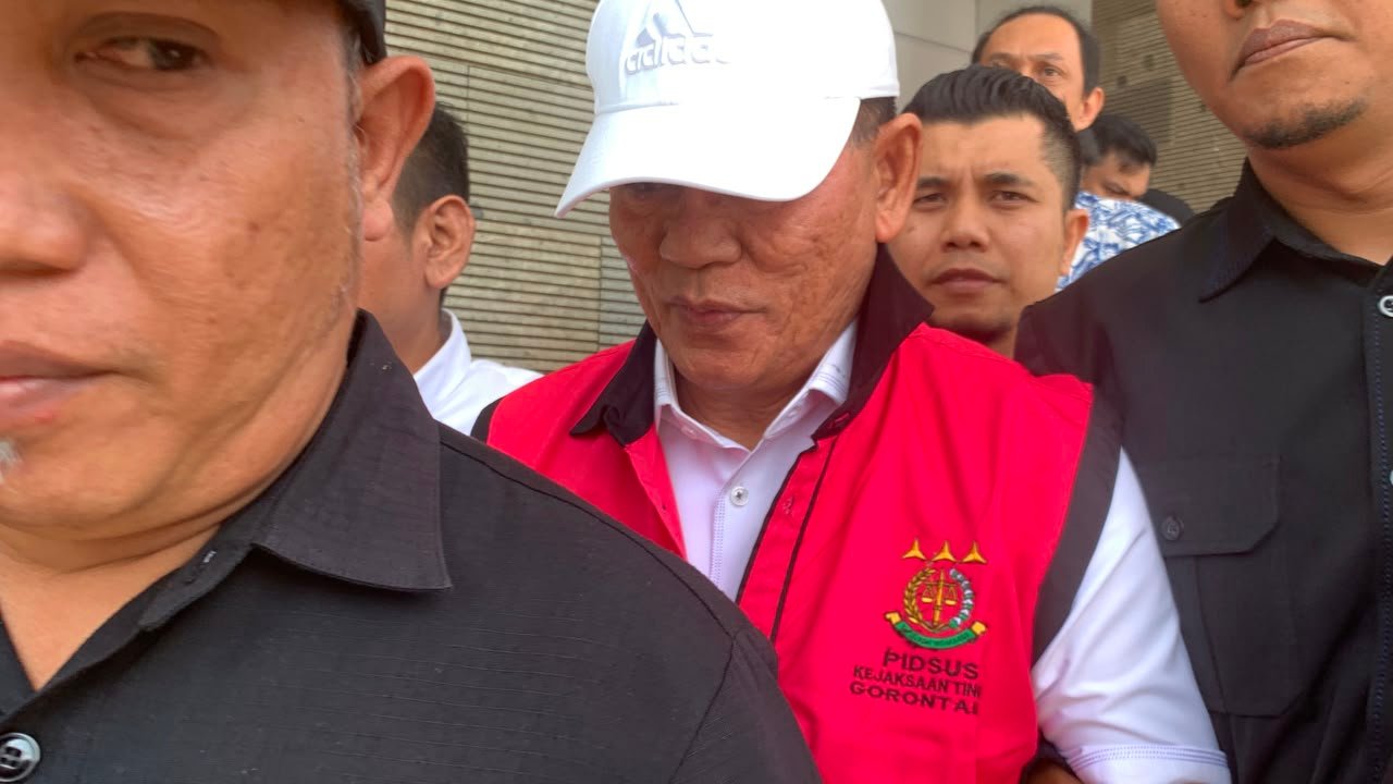 Salah satu tersangka dugaan korupsi dana hibah KONI Gorontalo saat digiring petugas menuju kendaraan tahanan, Jumat (21/8/2026)/Hibata.id
