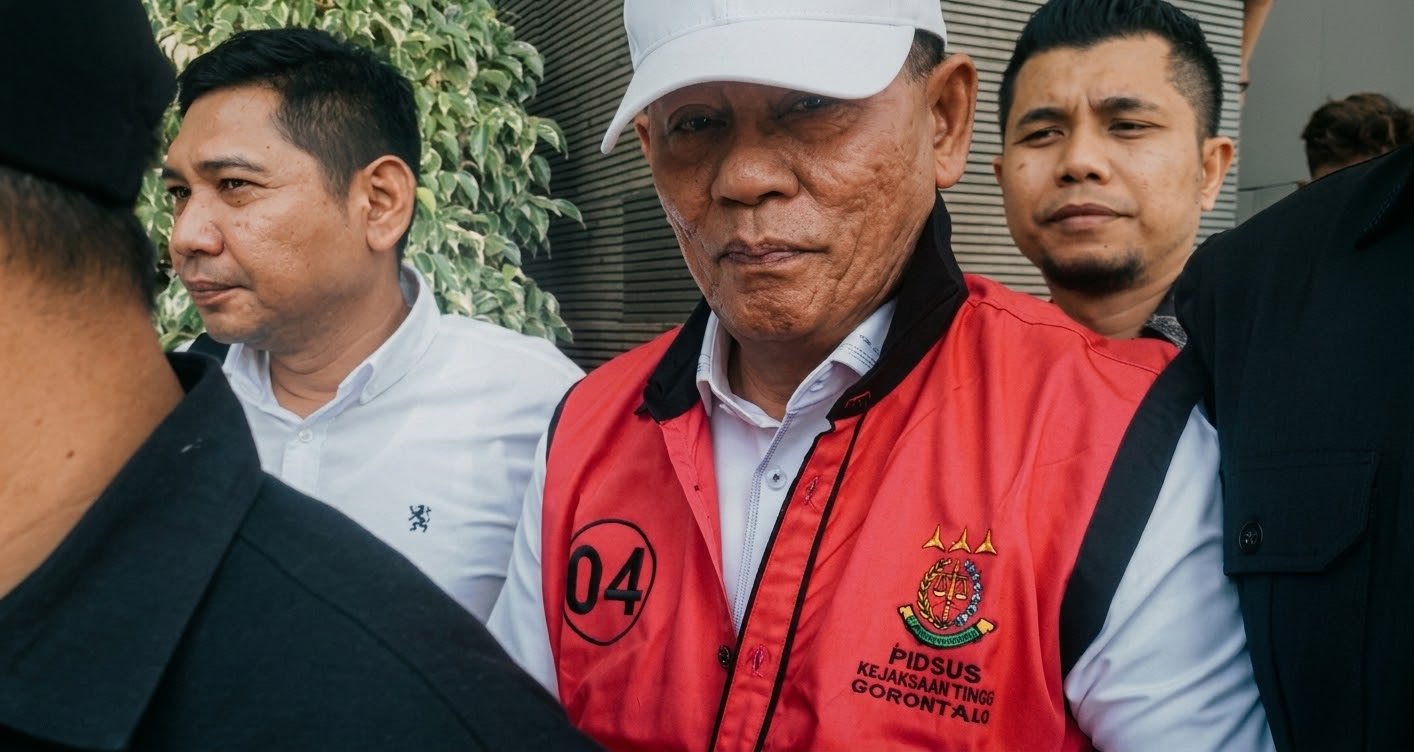 Ketua KONI Provinsi Gorontalo, Fikram Salilama, mengenakan rompi tahanan Kejaksaan Tinggi Gorontalo saat digiring menuju mobil tahanan usai menjalani pemeriksaan/Hibata.id