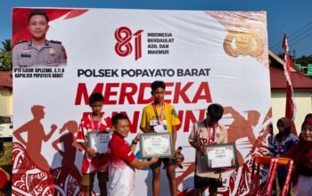 Kapolsek Popayato Barat IPTU Ilham Siplizand, S.Tr.K. saat menyerahkan penghargaan kepada peserta Merdeka Fun Run di Kecamatan Popayato Barat, Kabupaten Pohuwato/Hibata.id