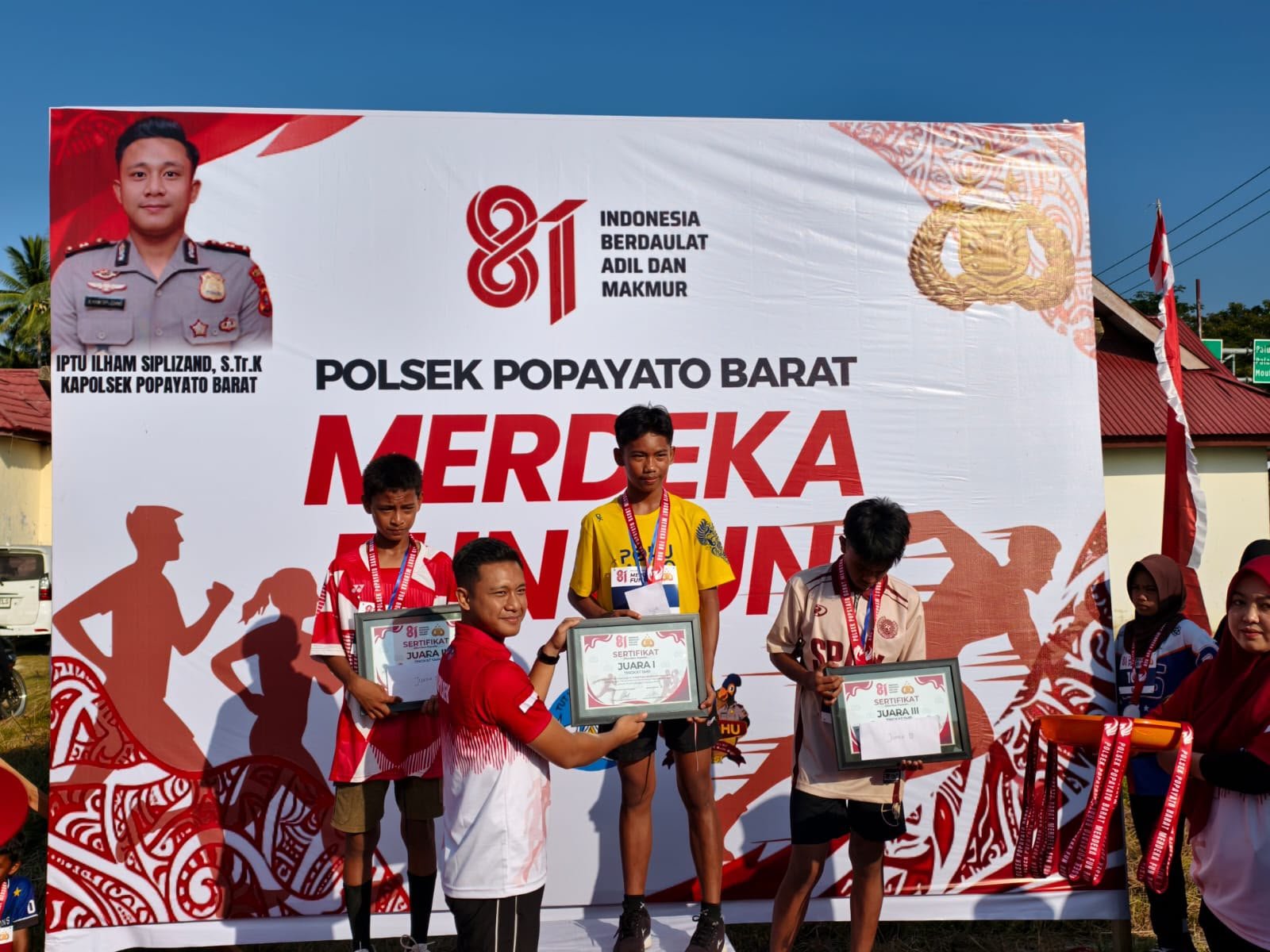 Kapolsek Popayato Barat IPTU Ilham Siplizand, S.Tr.K. saat menyerahkan penghargaan kepada peserta Merdeka Fun Run di Kecamatan Popayato Barat, Kabupaten Pohuwato/Hibata.id